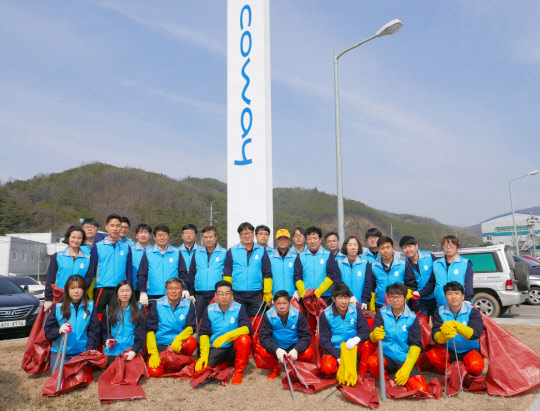 코웨이 임직원들이 유구천 환경 정화 활동을 마무리하고 기념촬영을 진행하고 있다. 코웨이 제공